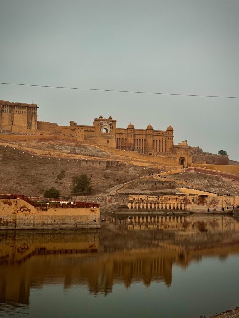 a large building sitting on top of a hill next to a body of water