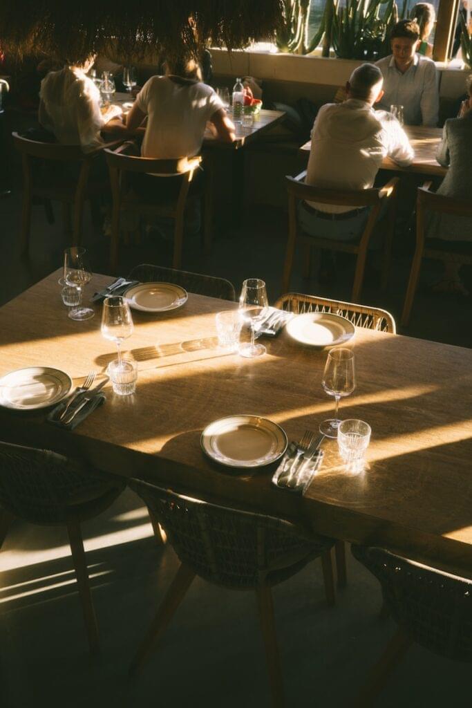 People dining at a sunlit restaurant table